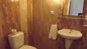 A bathroom with a toilet, sink, and a mirror. - Silver Hotel (Varna)