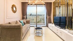 A modern living room with a sofa, a TV, and a balcony with a view. - Saigon Sirius (Ho Chi Minh City)