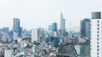 A cityscape with modern high-rise buildings, a river, and a bridge.