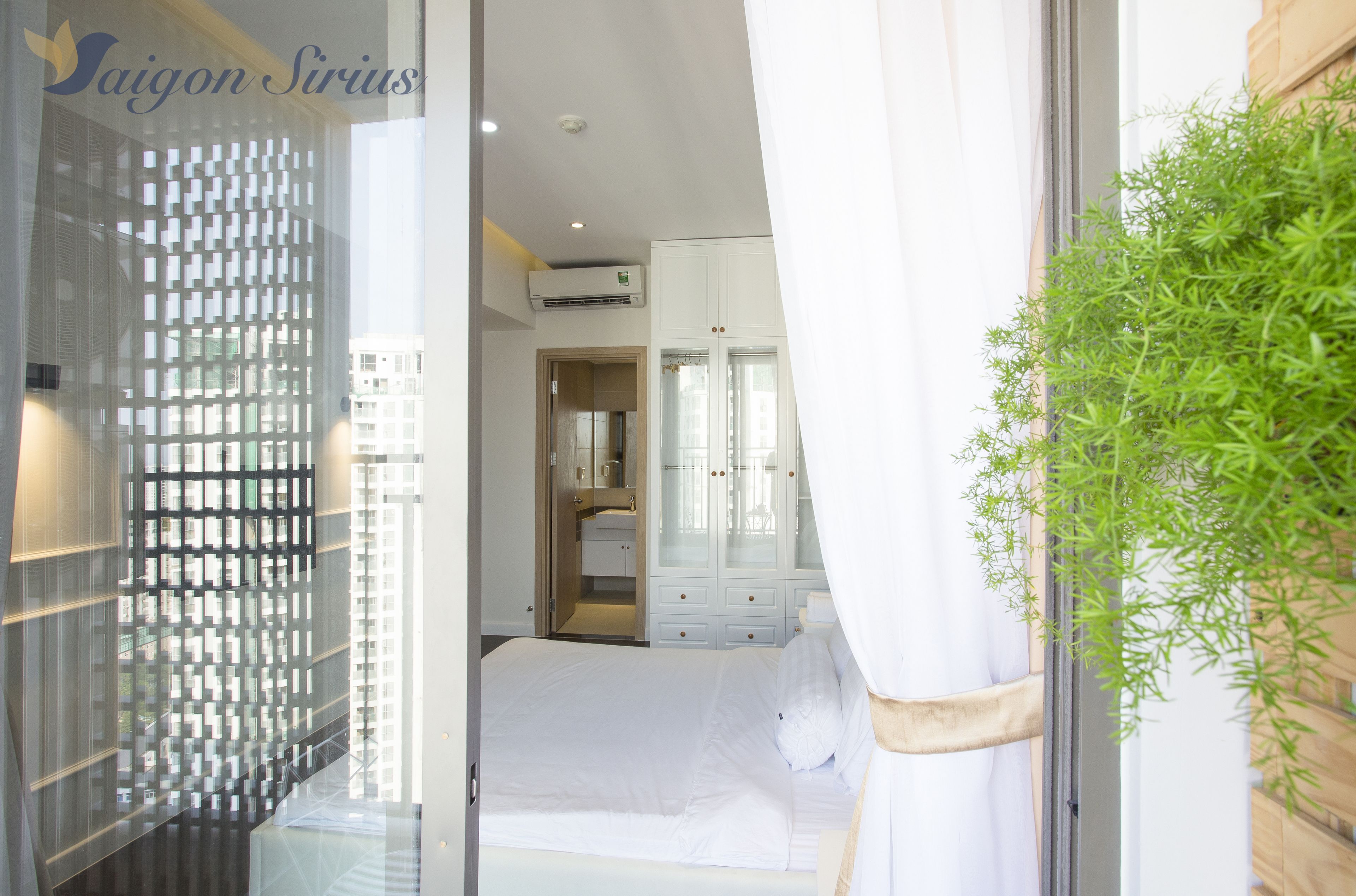 A bedroom with a bed, a wardrobe, and an air conditioning unit.