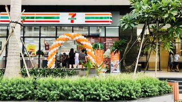 A 7-Eleven store with a large arch made of balloons.