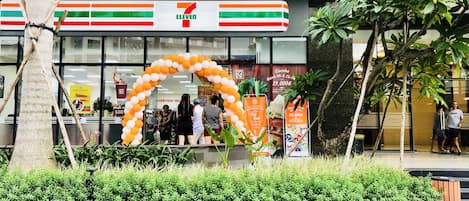 A 7-Eleven store with a large arch made of balloons.