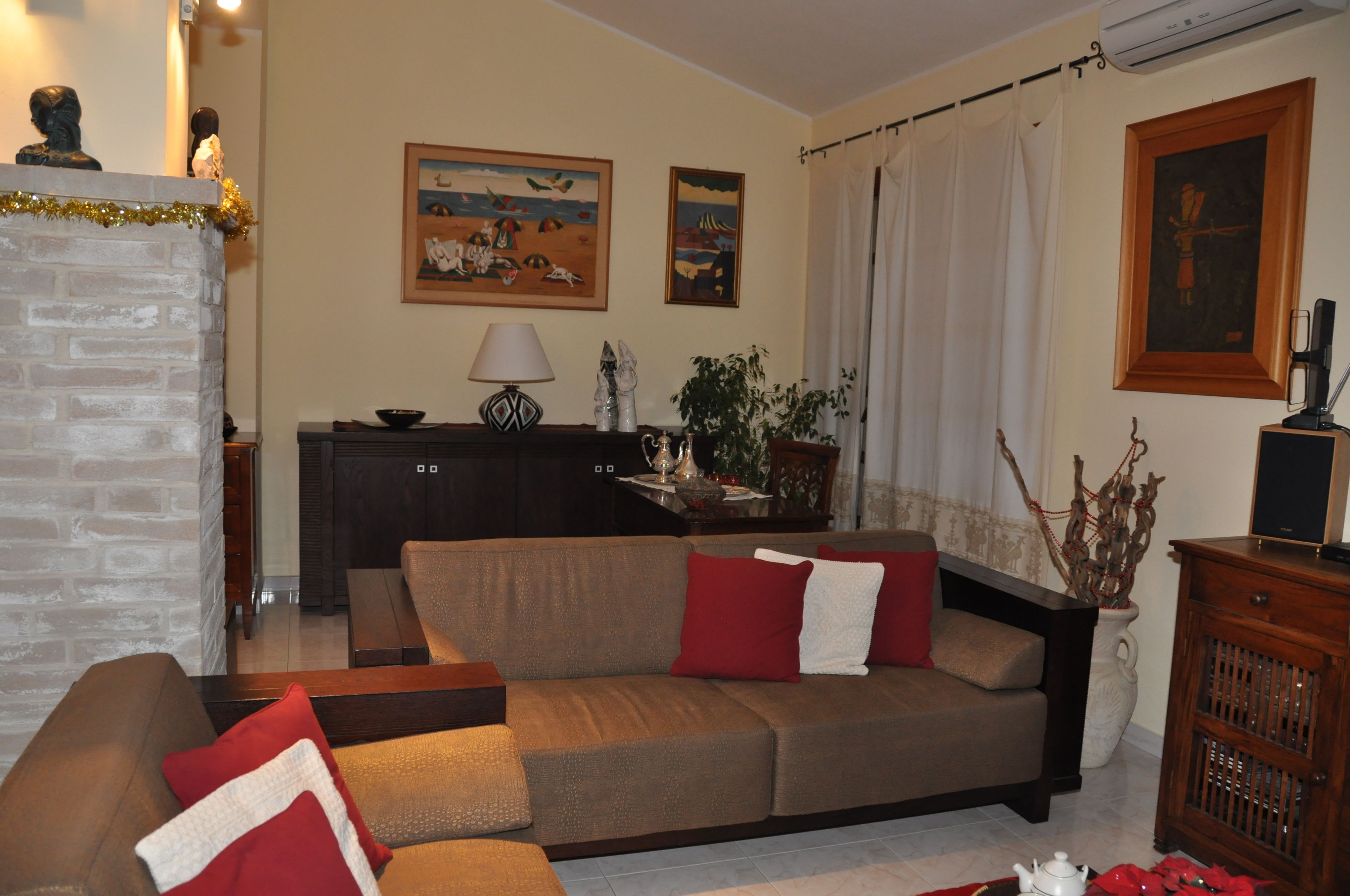 A living room with a sofa, a wooden cabinet, and a fireplace.