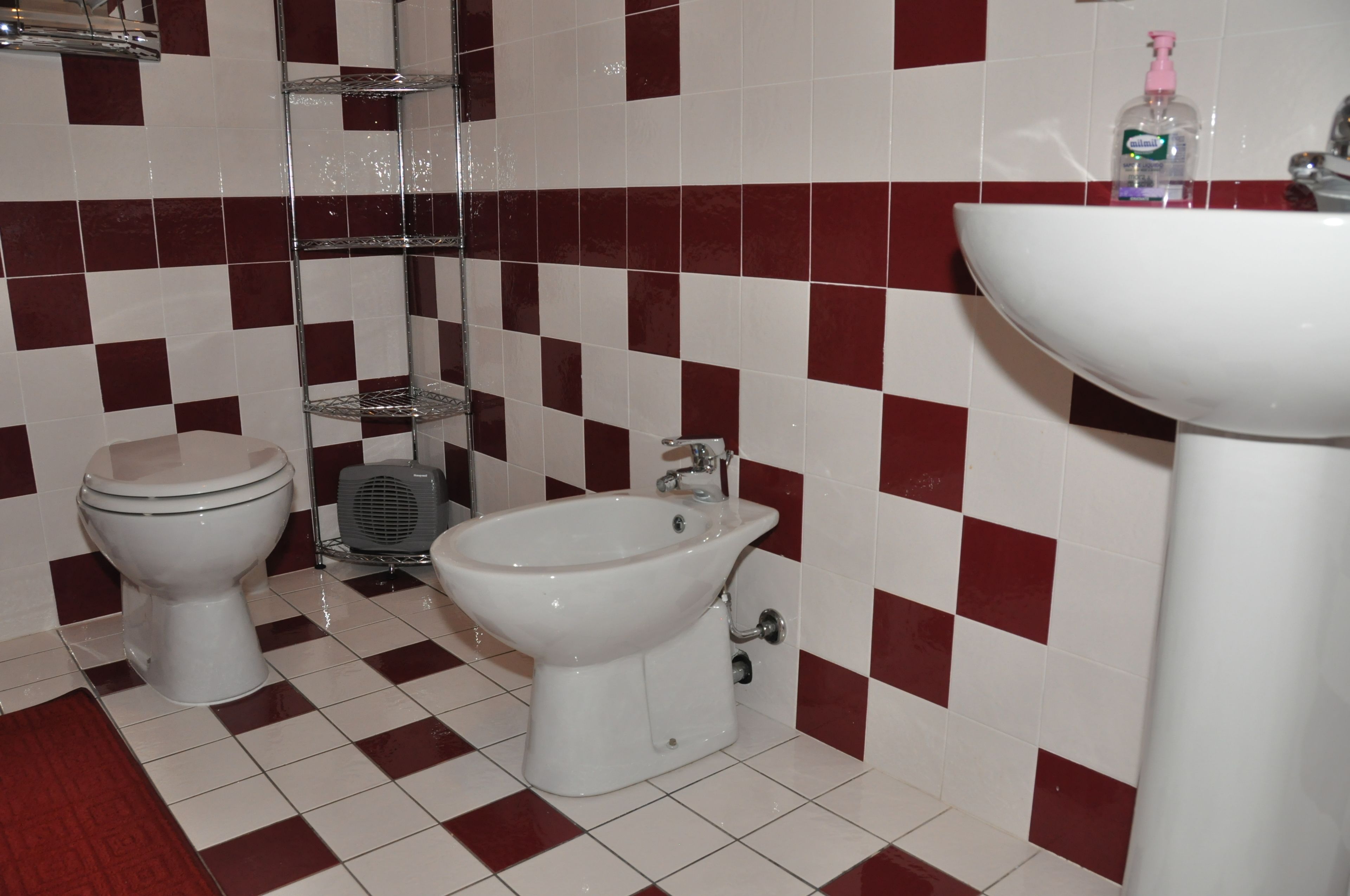 A bathroom with a toilet, bidet, and sink.