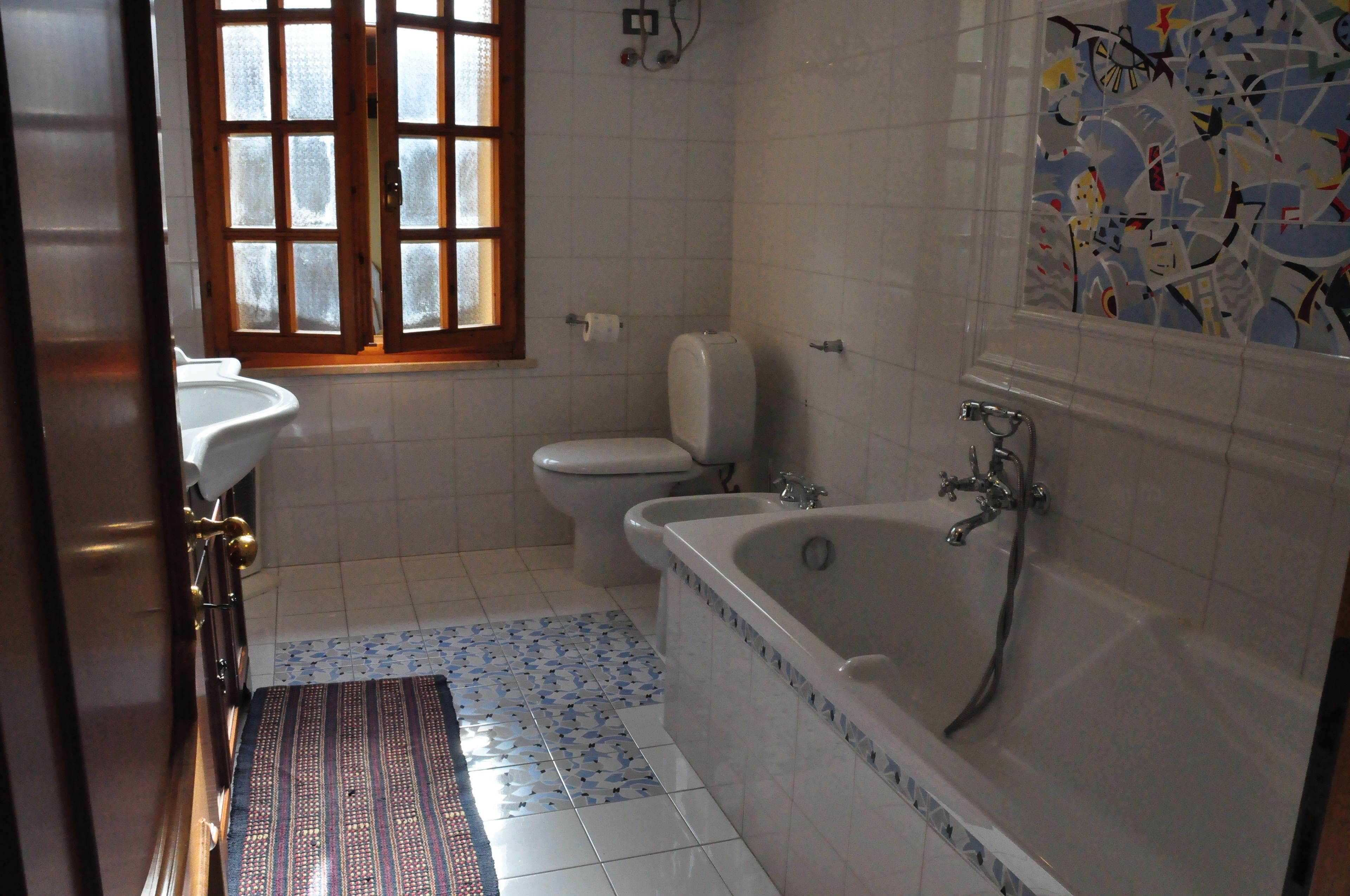 A bathroom with a toilet, sink, and bathtub.
