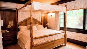 A four-poster bed with a wooden frame and a floral-patterned bedspread. - Springside Inn (Auburn)