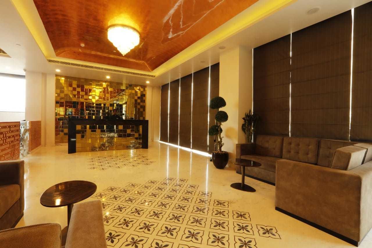 A lobby with a checkered floor, a sofa, a small table, and a reception area with a checkered wall and a counter.