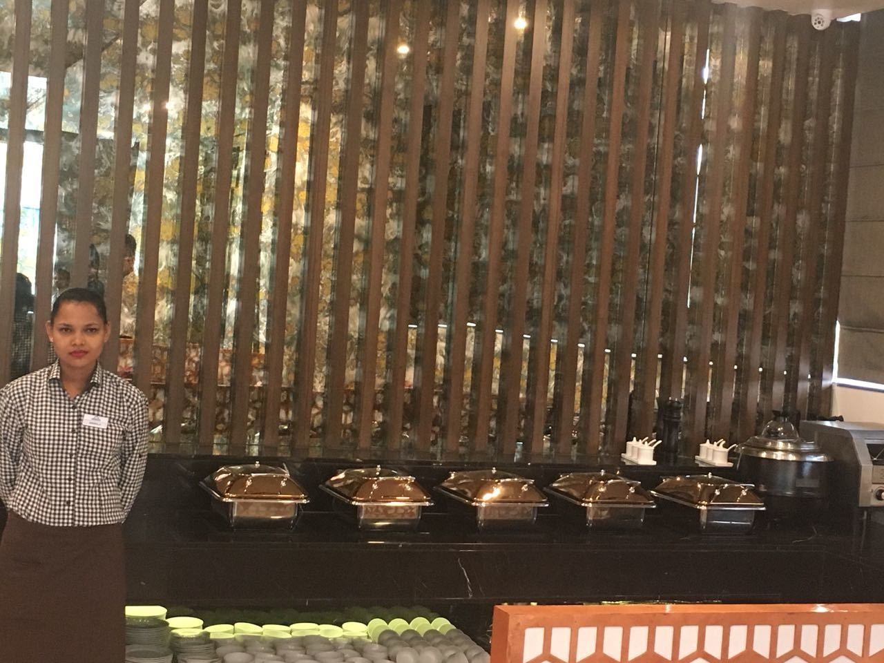Un buffet avec plusieurs points de service et une personne qui se tient devant.