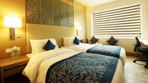 A hotel room with two beds, a desk, and a large window with blinds. - Days Hotel by Wyndham Jaipur Tonk Road (Jaipur)