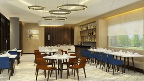 A modern dining area with multiple tables and chairs, a bar, and a large window with a view. - Days Hotel by Wyndham Jaipur Tonk Road (Jaipur)