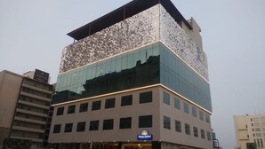 A modern hotel with a reflective facade, a Days Hotel sign, and a visible entrance. - Days Hotel by Wyndham Jaipur Tonk Road (Jaipur)