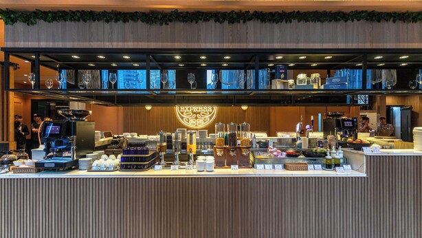Zona de buffet con diversas opciones de comida y bebida, que incluye una estación de café y una selección de refrescos.