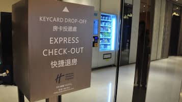 A sign for a hotel check-out area with a vending machine in the background.