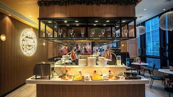 A restaurant counter with a pizza display, wine glasses, and a menu board.
