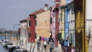 A narrow street with colorful buildings and boats docked along the water. - B&b dai Carari (Mira)