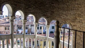 An arched stone structure with multiple openings, overlooking a cityscape with buildings and rooftops. - B&b dai Carari (Mira)