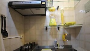 A kitchen with a gas stove, a sink, and a glass shelf with kitchen utensils. - GoHouse Vergueiro 901 (Rio de Janeiro)