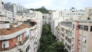 A high-rise residential building with multiple balconies and a central green space. - GoHouse Vergueiro 901 (Rio de Janeiro)