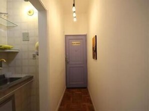 A narrow hallway with a door labeled "Entrance" and a light fixture above it.