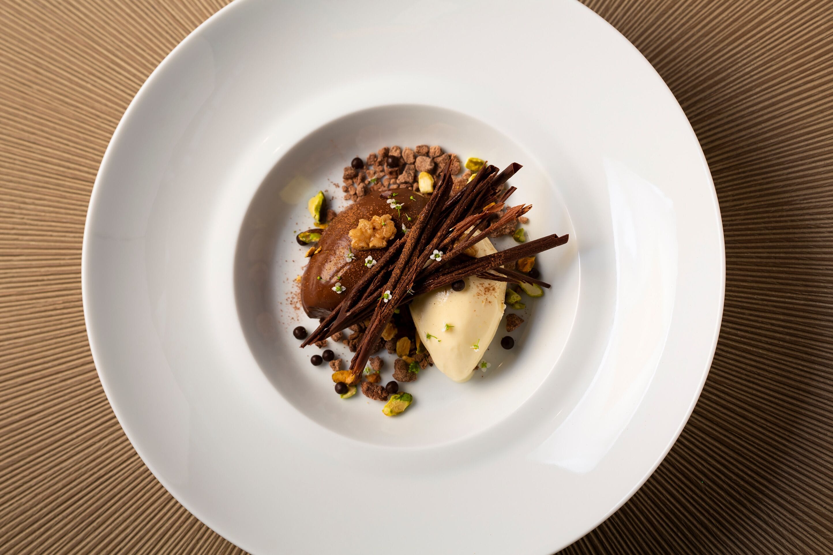 A white plate with a dessert on a textured brown surface.