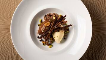 A white plate with a dessert on a textured brown surface.