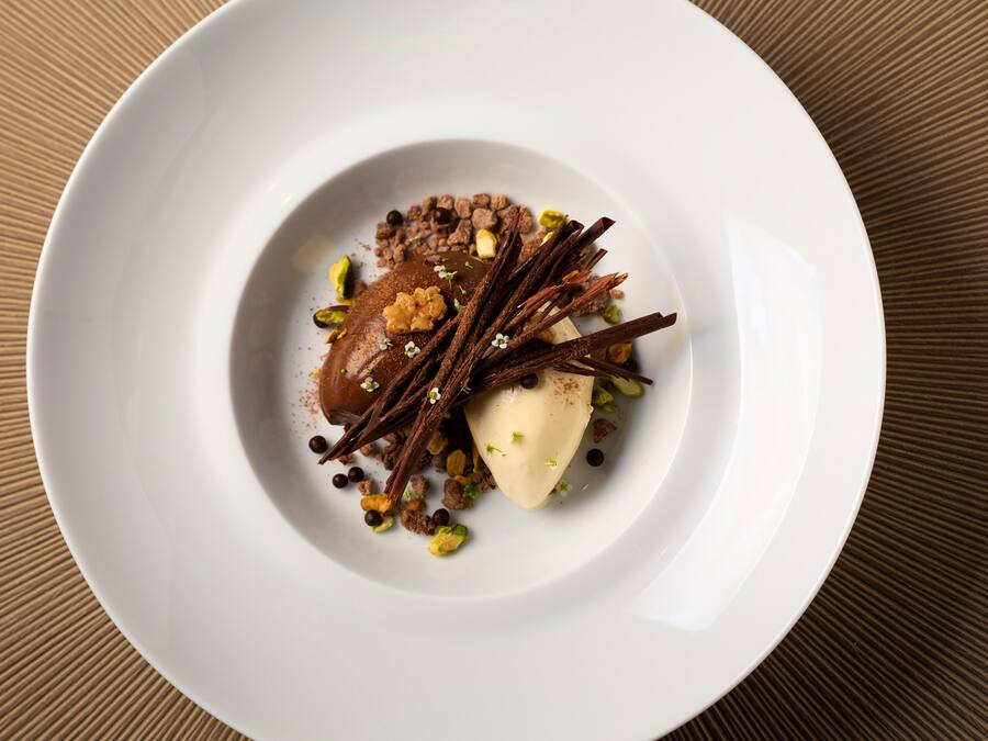 A white plate with a dessert on a textured brown surface.