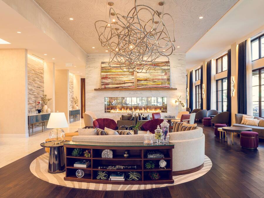 A spacious living area with a modern chandelier, comfortable seating, and a fireplace.