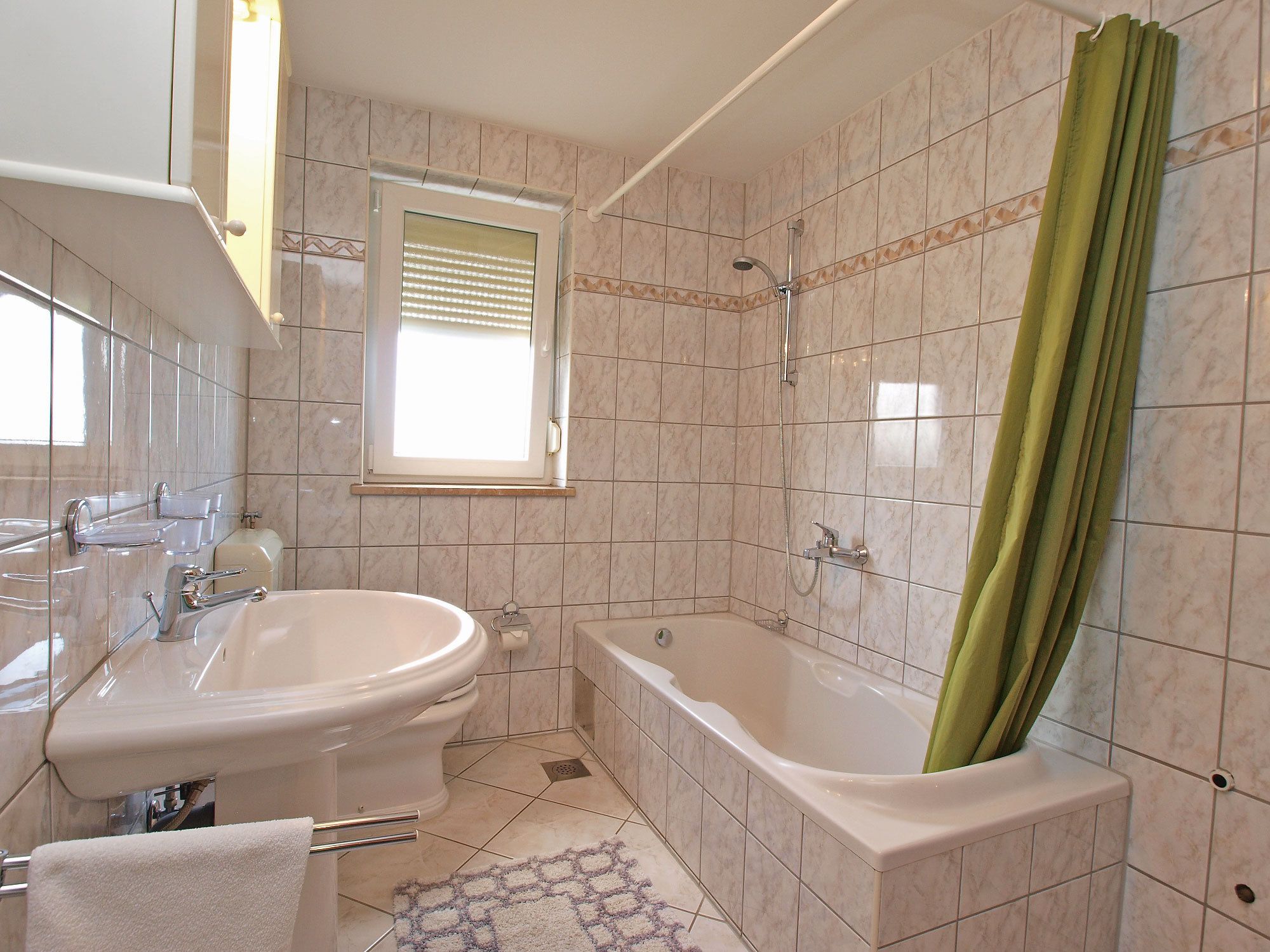 A bathroom with a bathtub, a toilet, and a sink.