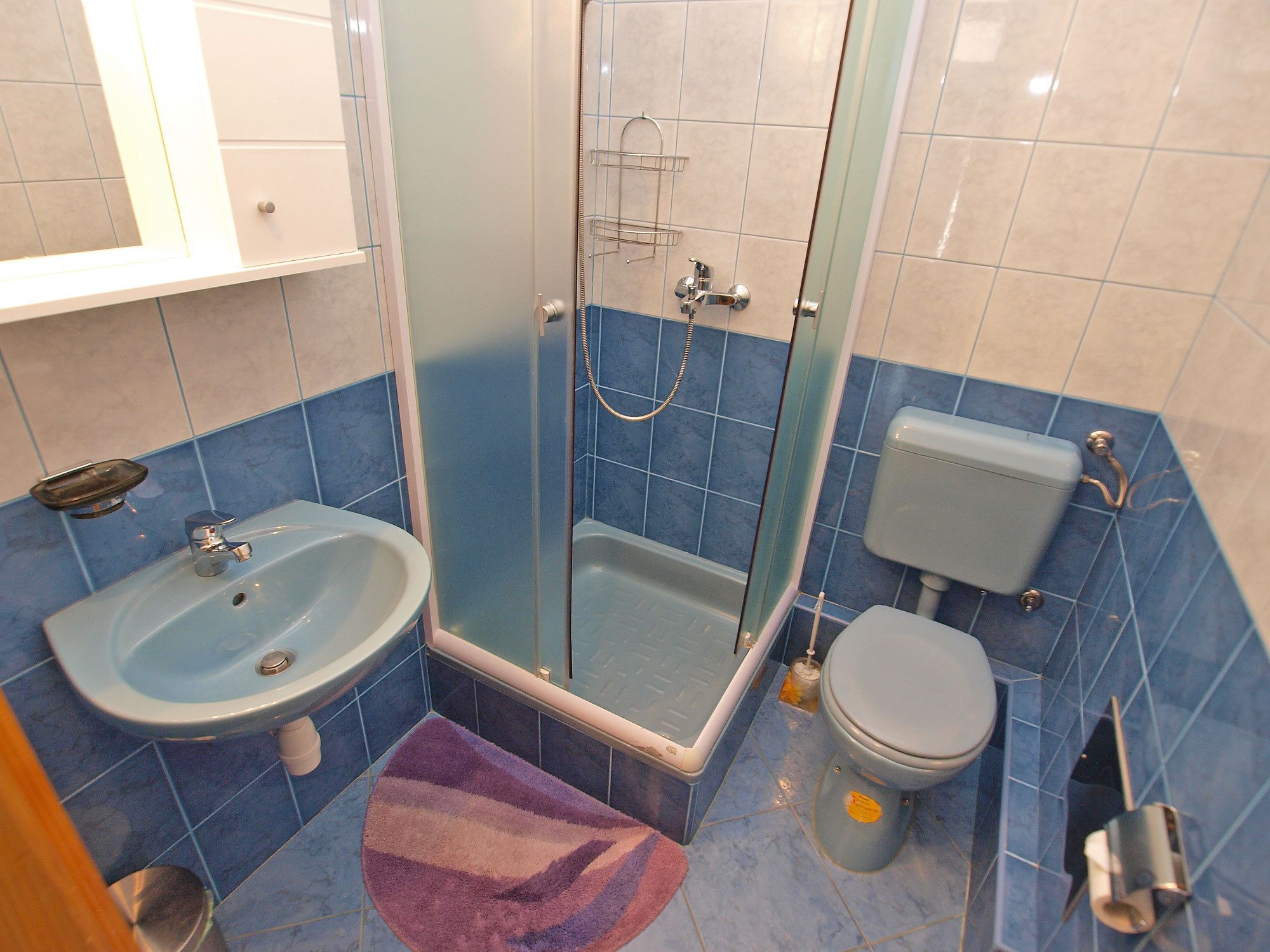 A bathroom with a sink, toilet, and shower.