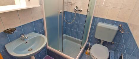 A bathroom with a sink, toilet, and shower.