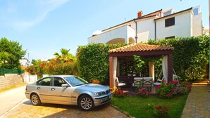 A car parked in a driveway with a garden and a pergola. - Apartment Marija 85 (Fazana)