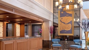 A hotel reception area with a marble floor, wooden reception desk, and a large chandelier. - Millennium Istanbul Golden Horn (Istanbul)