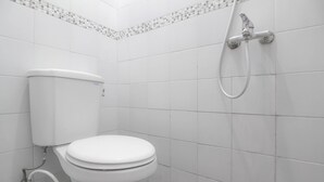 A bathroom with a toilet, a shower, and tiled walls. - RedDoorz Plus near Hartono Mall (Depok)