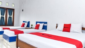 A hotel room with three beds, each with a red and white bedspread and matching pillows. - RedDoorz Plus near Hartono Mall (Depok)