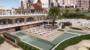 Un hotel con bar en la azotea, piscina al aire libre y zona de estar con sombrillas.