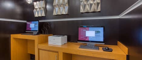 Ein Empfangsschalter mit zwei Computern, einem Drucker und dekorativen Wandverkleidungen.