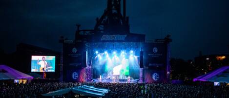 A large outdoor concert stage with a crowd in front.