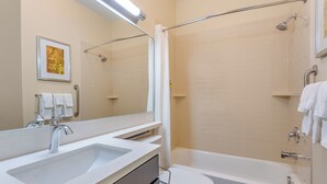 Een badkamer met een wastafel, toilet en bad.