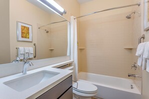 Een badkamer met een wastafel, toilet en bad.