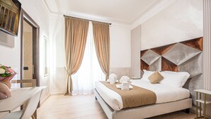 A hotel room with a bed, a desk, and a window with curtains. - COLA di Rienzo suite (Rome)