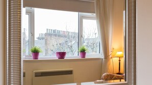 A room with a window, a radiator, and a lamp. - 1 Bedroom Flat in South Kensington (London)