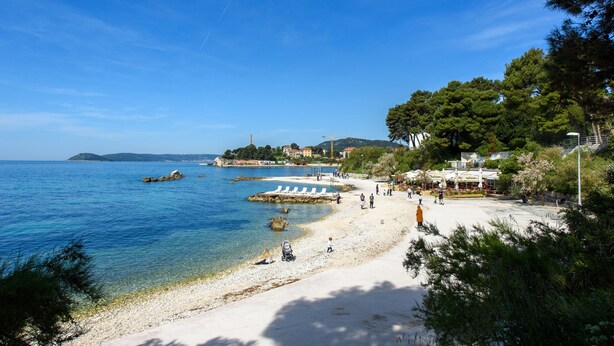 A beach with clear blue water, a sandy shore, and a few people. - Best Location Apartments (Split)