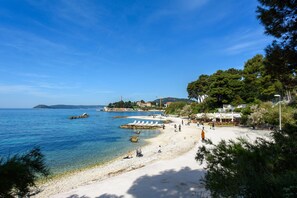 A beach with clear blue water, a sandy shore, and a few people. - Best Location Apartments (Split)