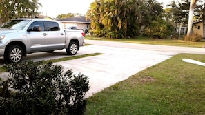 Stroll up to a residence with a paved driveway and beautifully manicured lawn.
