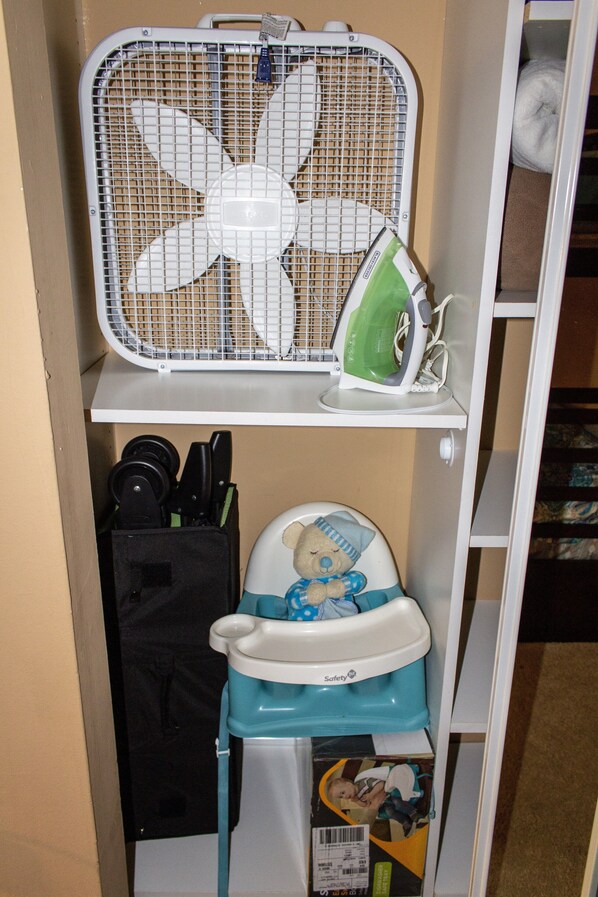 A storage area with a fan, an iron, and a baby seat. - 5 O'Clock Somewhere getaway-Walk/Bike to Beach,Shops ,Fenced private doggie area (Naples)