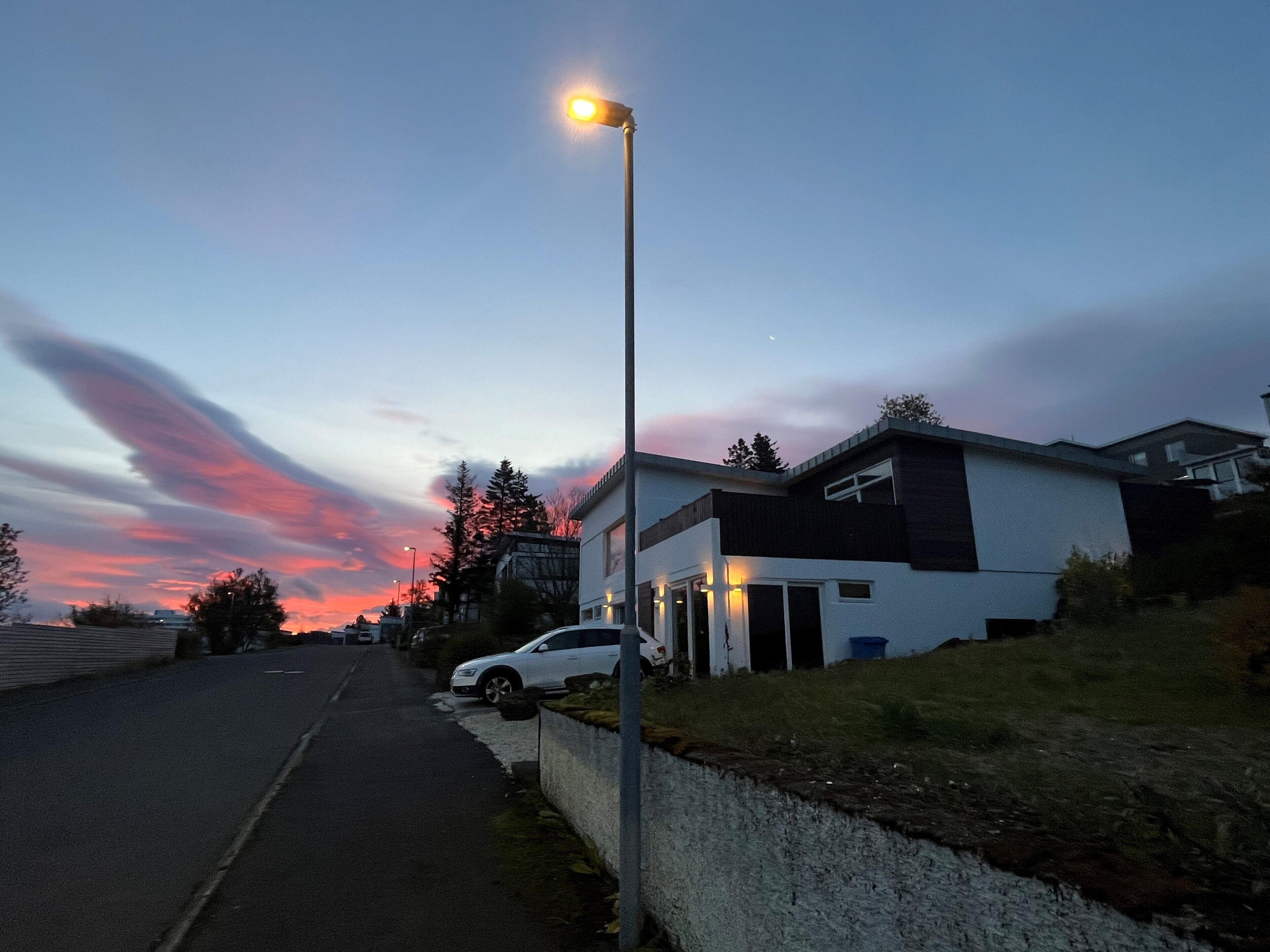 A modern house with a driveway and a street lamp.