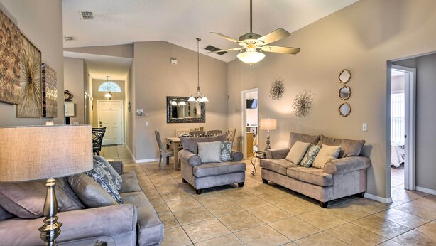 A spacious living room with two sofas, a coffee table, and a ceiling fan. - Clermont Home w/ Pool & Game Room: 10 Mi to Parks! (Clermont)