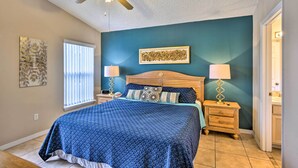 A bedroom with a bed, nightstands, a ceiling fan, and artwork on the walls. - Clermont Home w/ Pool & Game Room: 10 Mi to Parks! (Clermont)