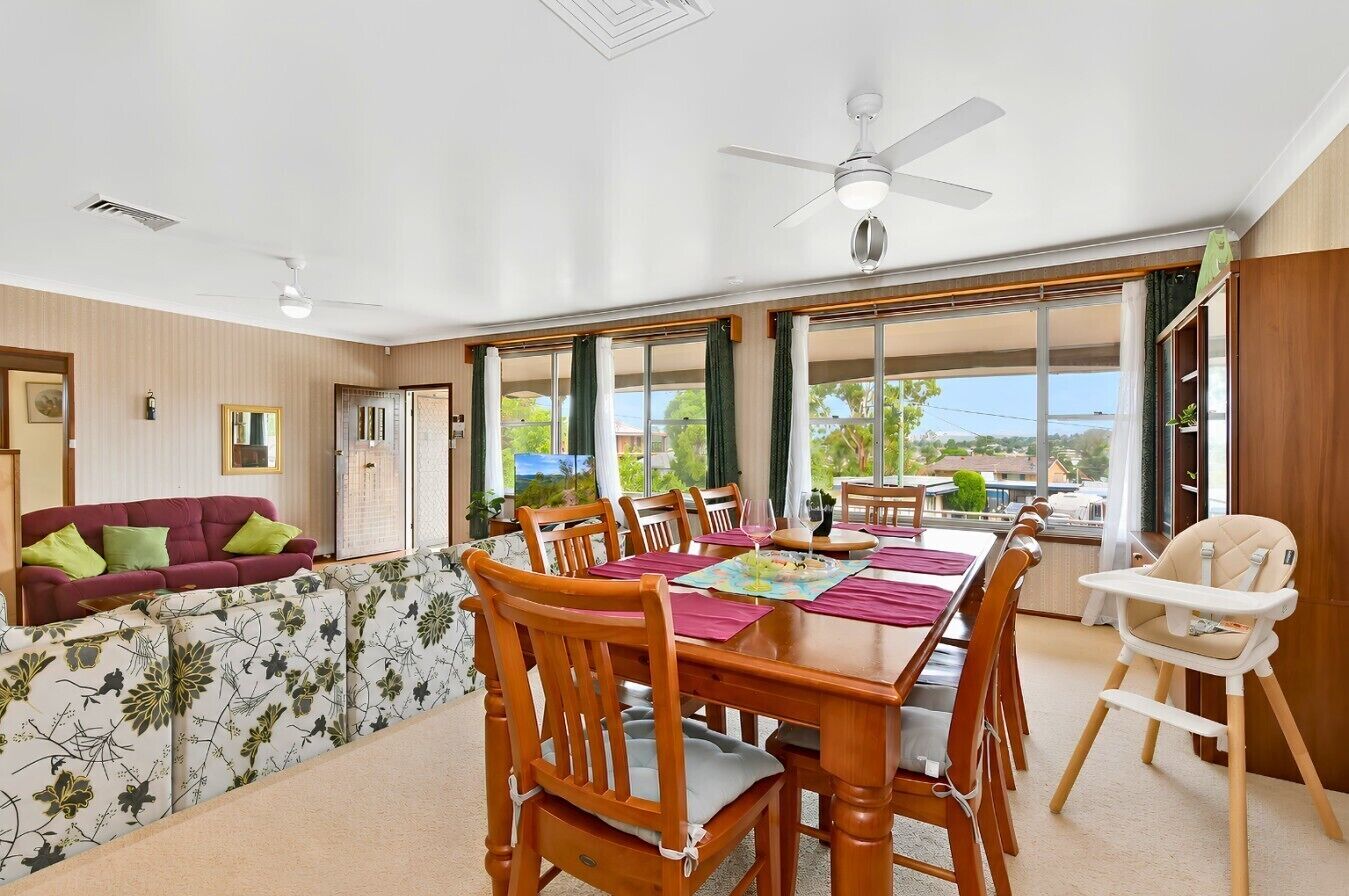 A dining area with a table, chairs, and a high chair.