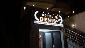 A hotel entrance with a sign reading "HOTEL DENIS & SPA" and amenities listed as massage, sauna, Turkish bath, and lounge bar. - Hotel Denis & Spa (Pristina)